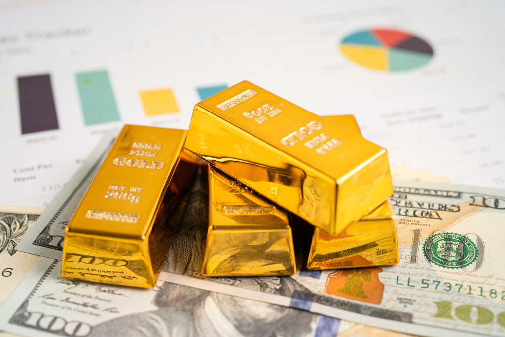 gold-bar-in-shopping-cart-on-us-dollar-banknotes-m-2023-08-16-23-41-20-utc
